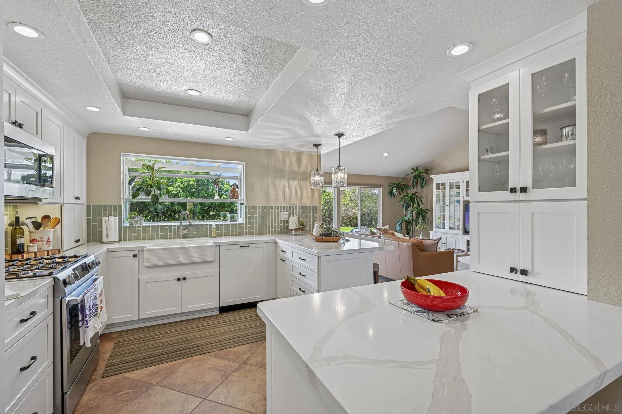 602 Hollyridge Drive Encinitas, CA 92024 - Photo 11 of 50 a kitchen that has a lot of white cabinets and stainless steel appliances