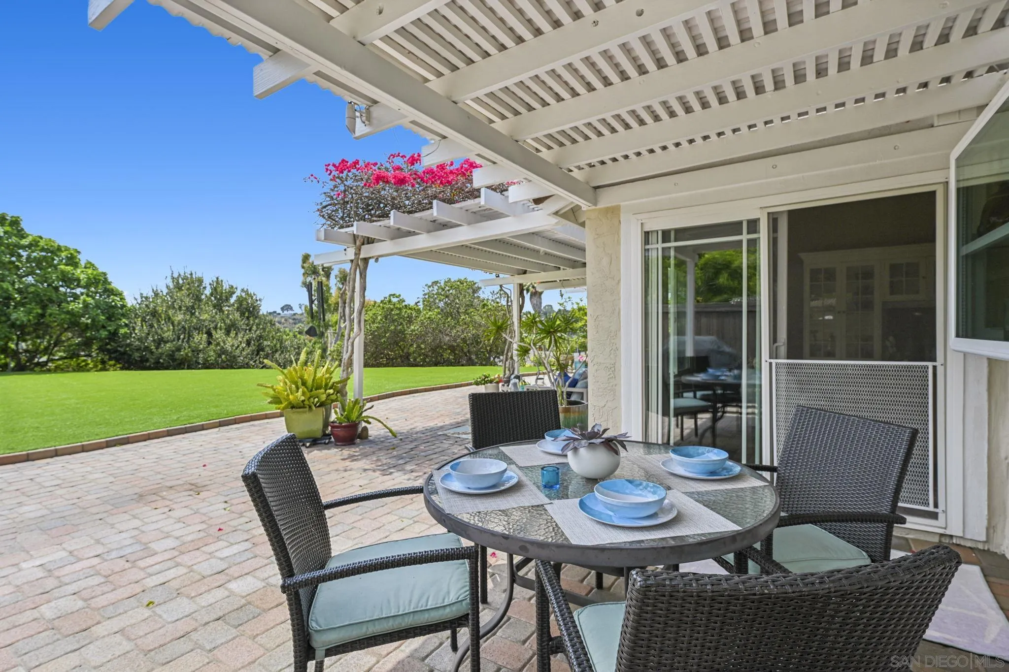 602 Hollyridge Drive Encinitas, CA 92024 - Photo 32 of 50 a view of a patio with a table and chairs and floor to ceiling window and garden