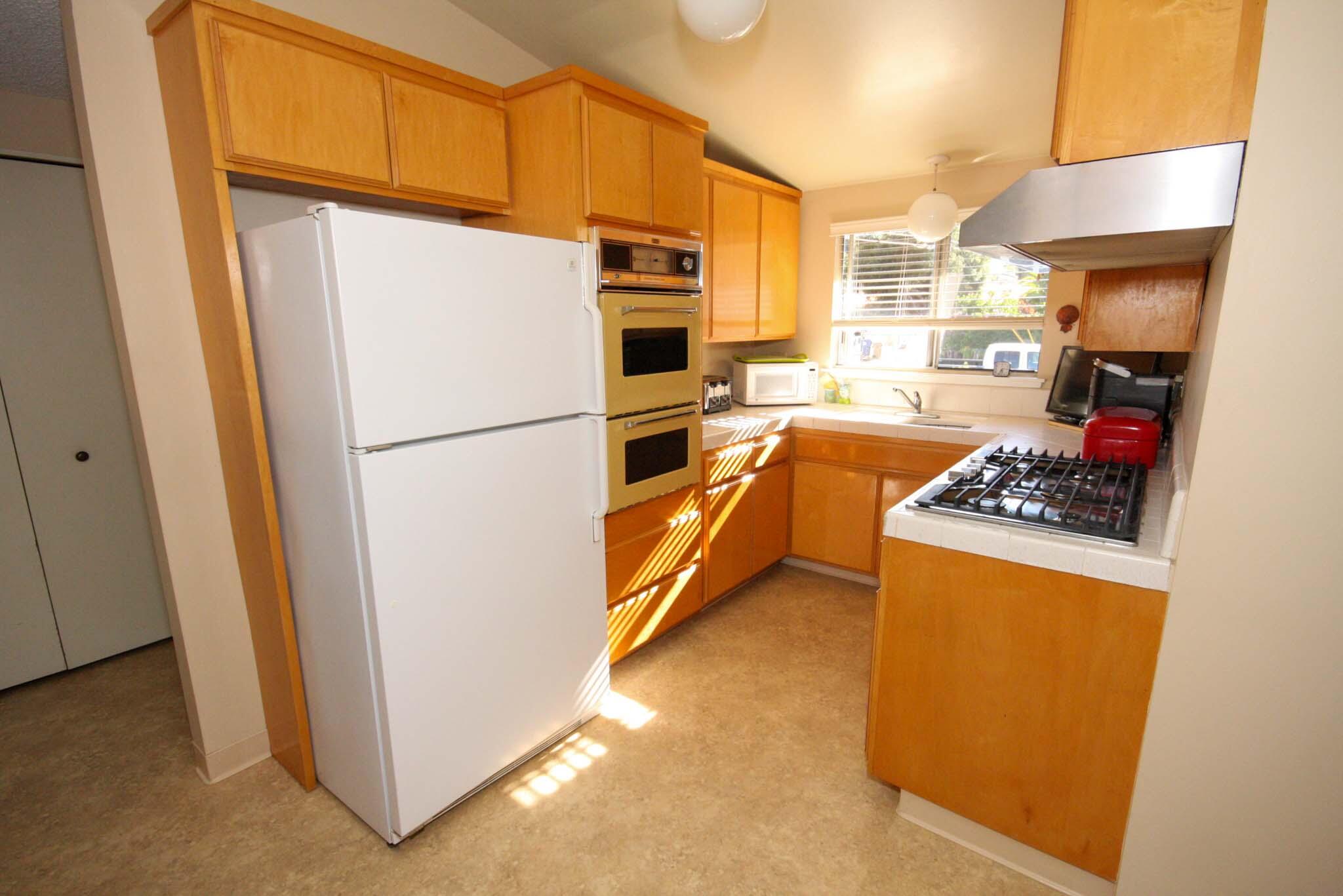 648 Dara Road Goleta, CA 93117 - Photo 11 of 14 a kitchen with stainless steel appliances a refrigerator a stove a sink and white cabinets