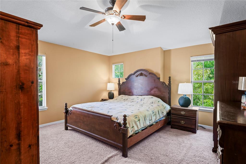 8604 Great Egret Trace New Port Richey, FL 34653 - Photo 17 of 55 a bedroom with a bed lamp and a chandelier