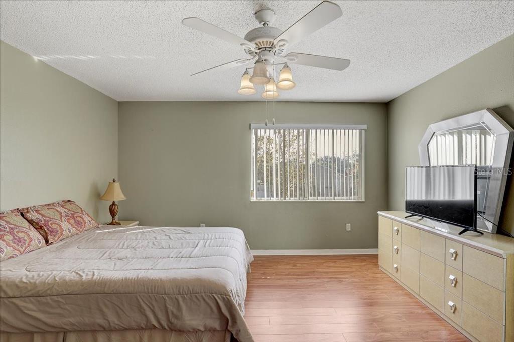 12657 Longcrest Drive Riverview, FL 33579 - Photo 19 of 55 a bedroom with a large bed and a flat tv screen on dresser