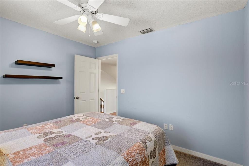 12657 Longcrest Drive Riverview, FL 33579 - Photo 25 of 55 a bedroom with a bed and a chandelier