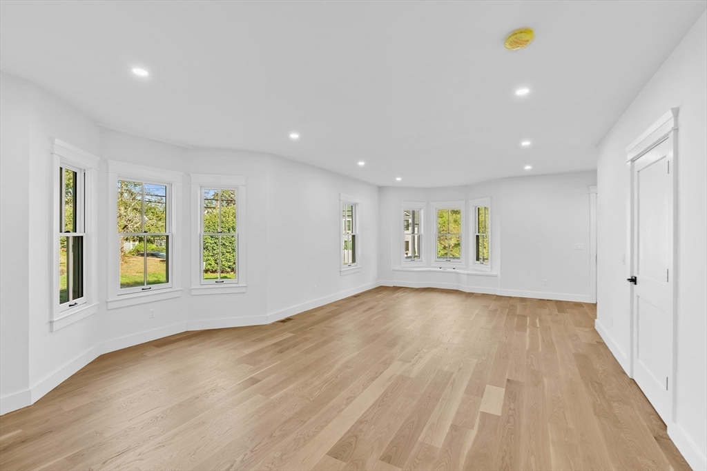 83 Eliot Street Natick, MA 01760 - Photo 12 of 30 a view of an empty room with a window and wooden floor