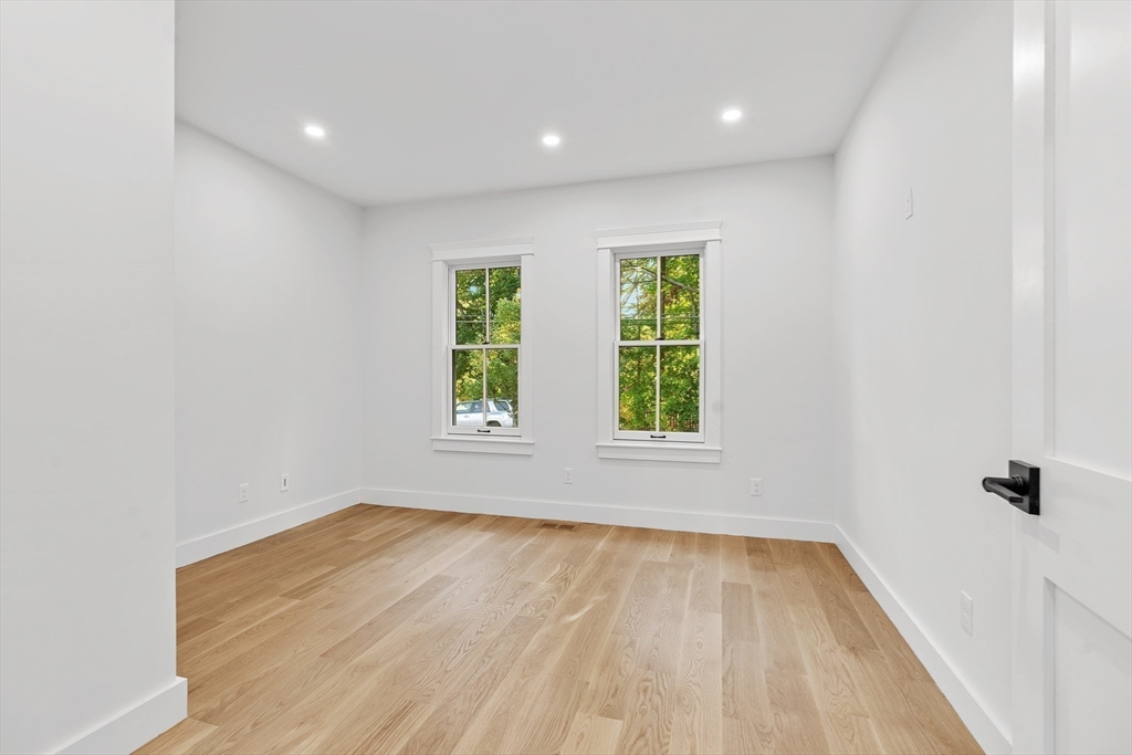 83 Eliot Street Natick, MA 01760 - Photo 13 of 30 an empty room with wooden floor and windows