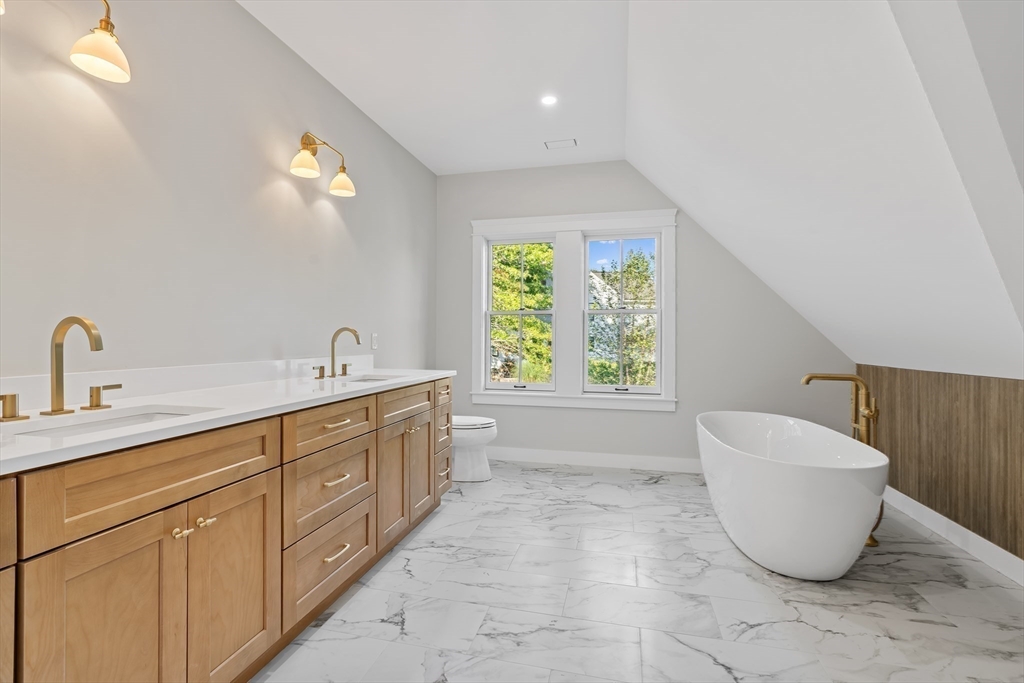 83 Eliot Street Natick, MA 01760 - Photo 16 of 30 a spacious bathroom with a bathtub sink and mirror