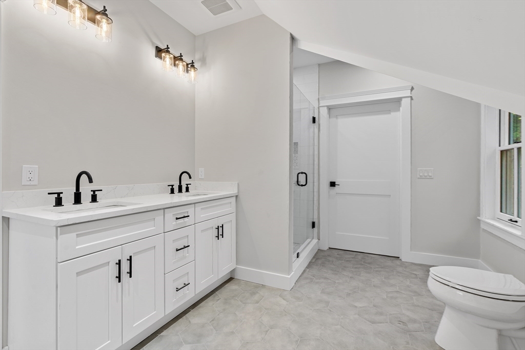 83 Eliot Street Natick, MA 01760 - Photo 23 of 30 a spacious bathroom with 2 sink toilet and a mirror