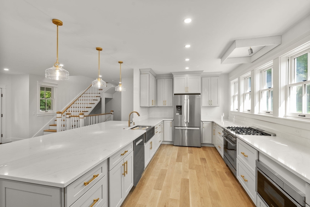 83 Eliot Street Natick, MA 01760 - Photo 4 of 30 an open kitchen with a sink a stove and a wooden floors
