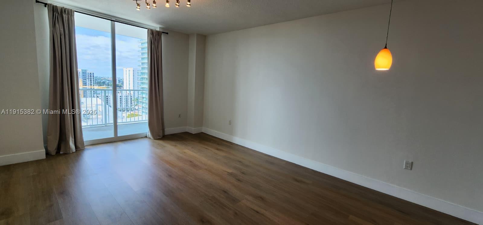 1250 South Miami Avenue, Unit 1911 Miami, FL 33130 - Photo 6 of 23 an empty room with wooden floor and windows