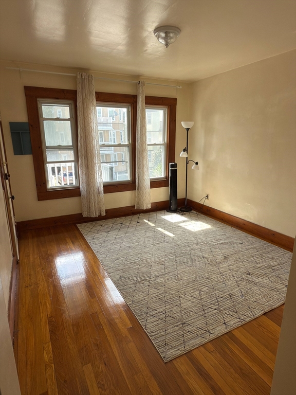 3965 Washington Street Boston, MA 02131 - Photo 4 of 18 wooden floor in an empty room with a window