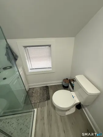 a bathroom with a toilet a sink and mirror
