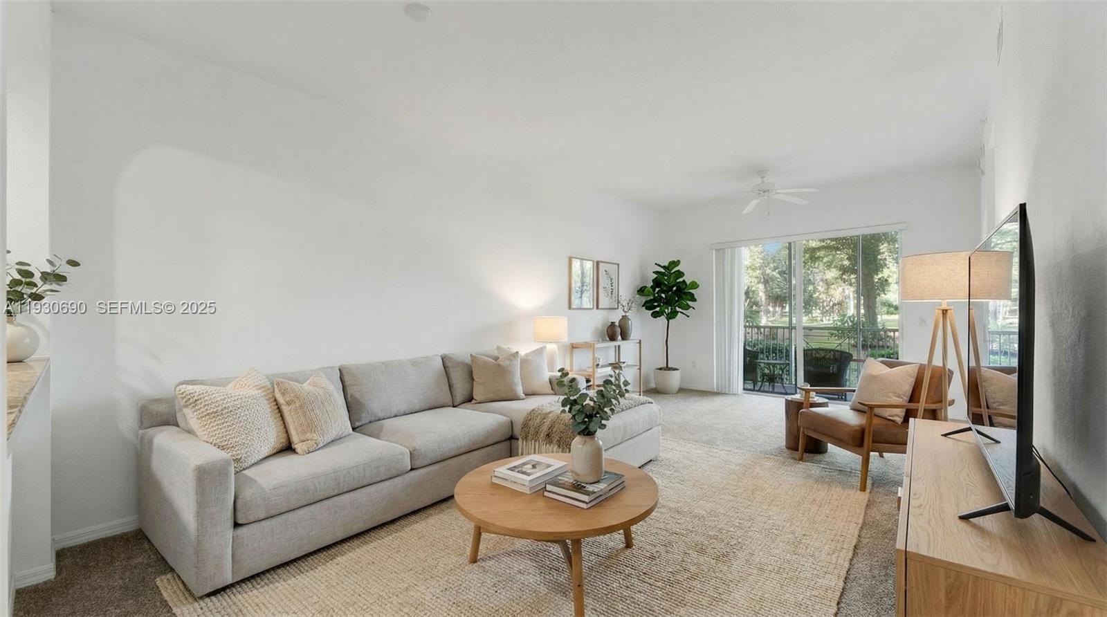 3600 Oaks Clubhouse Drive, Unit 103 Pompano Beach, FL 33069 - Photo 8 of 16 a living room with furniture potted plant and a large window