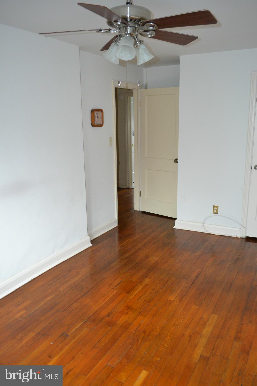 203 Grove Park Road Baltimore, MD 21225 - Photo 12 of 23 an empty room with wooden floor and windows