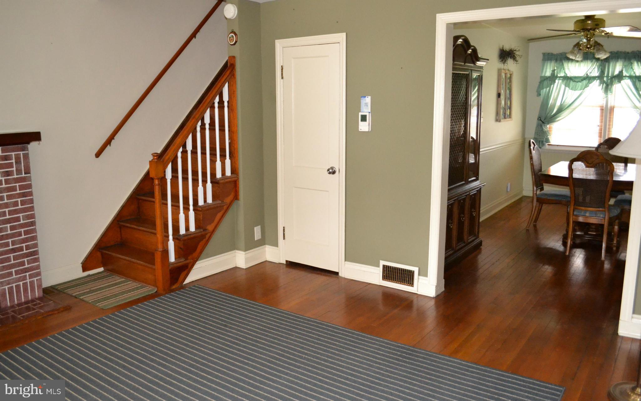 203 Grove Park Road Baltimore, MD 21225 - Photo 4 of 23 a view of a hallway with wooden floor and staircase