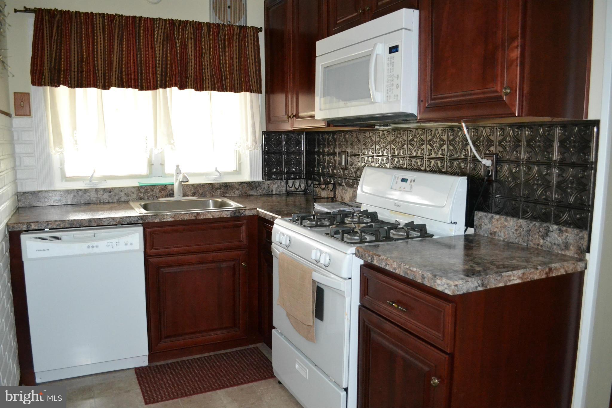 203 Grove Park Road Baltimore, MD 21225 - Photo 5 of 23 a kitchen with granite countertop a sink stove and cabinets