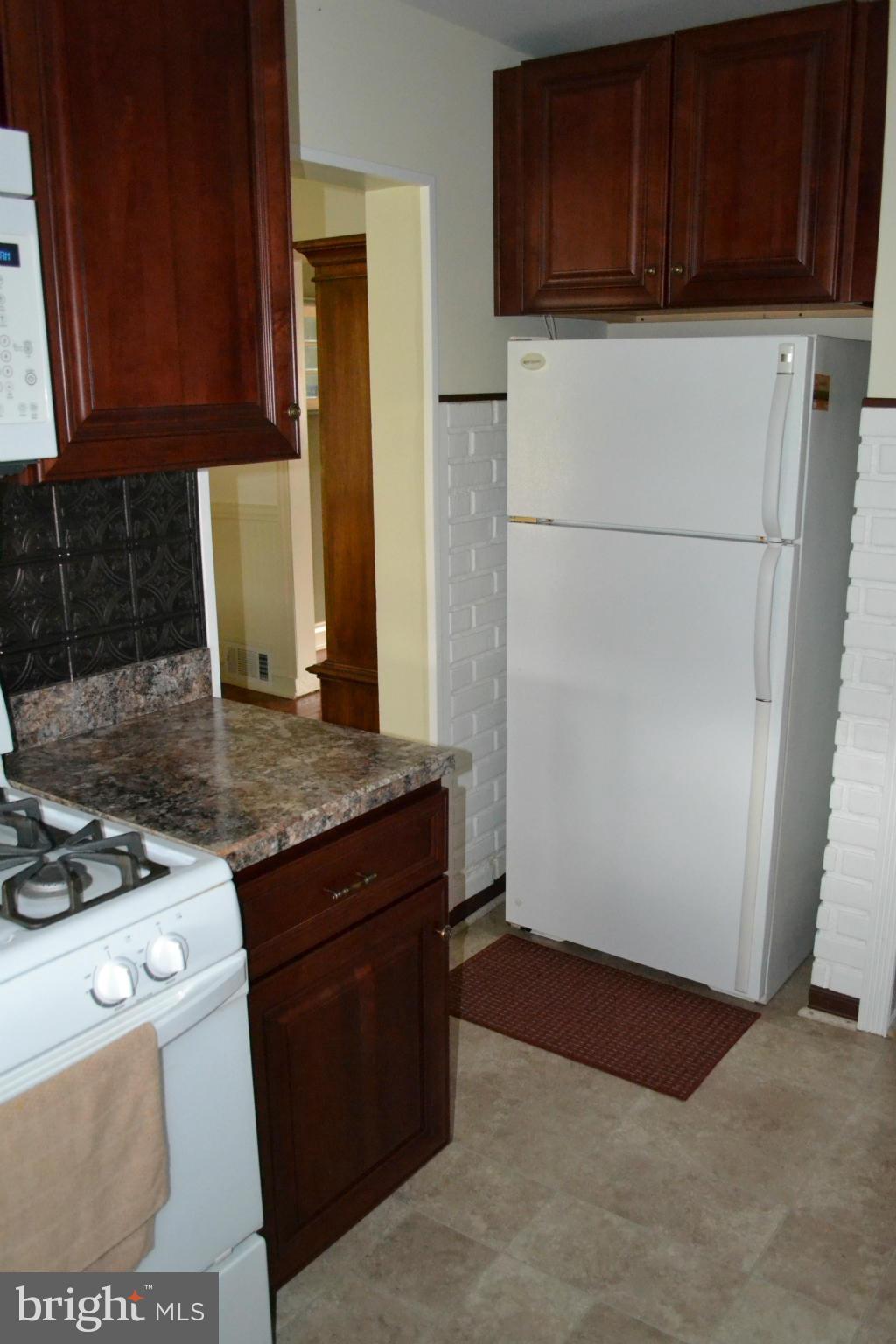 203 Grove Park Road Baltimore, MD 21225 - Photo 7 of 23 a kitchen with a stove and a refrigerator
