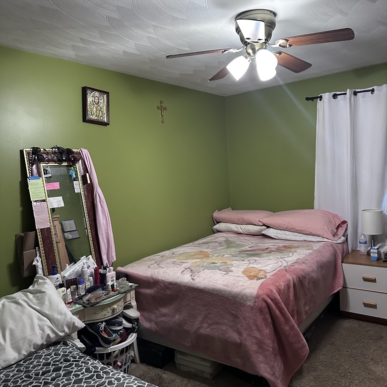 1163 Whipple Road Tewksbury, MA 01876 - Photo 7 of 31 a bedroom with a bed and a chandelier