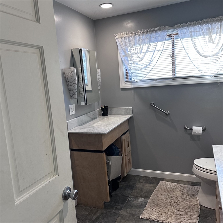 1163 Whipple Road Tewksbury, MA 01876 - Photo 9 of 31 a bathroom with a sink a toilet and a mirror