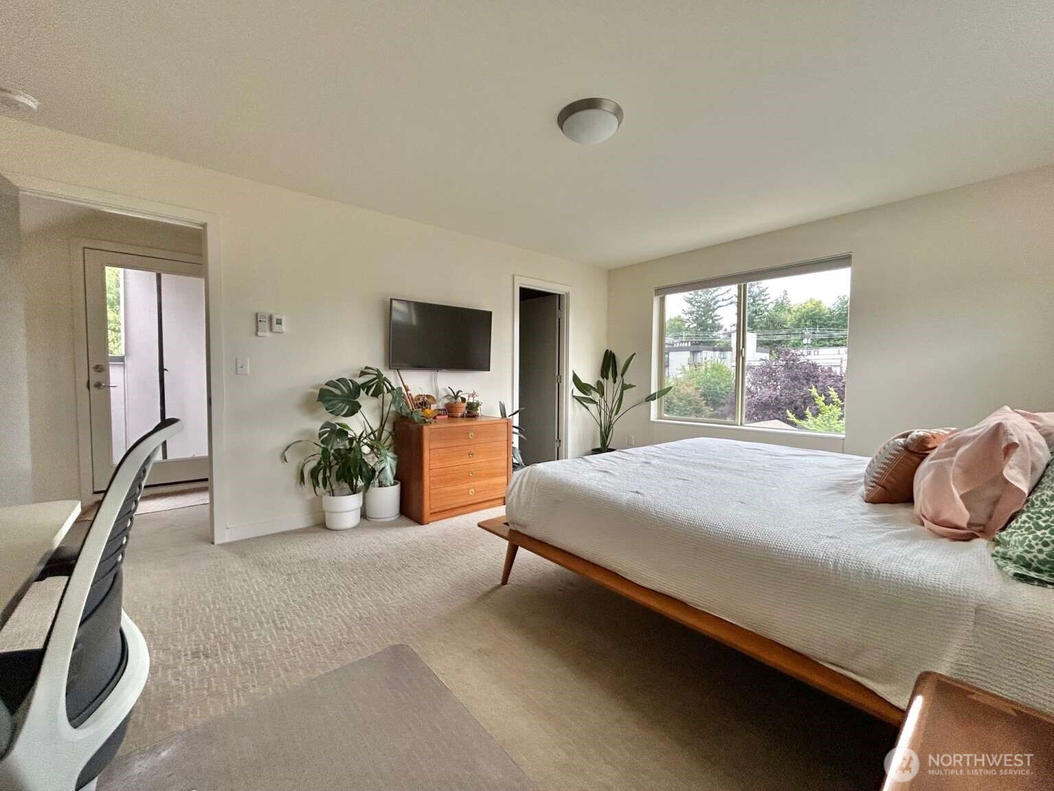 4852 40th Avenue Southwest, Unit B Seattle, WA 98116 - Photo 19 of 25 a bedroom with a bed and a flat tv screen next to a window