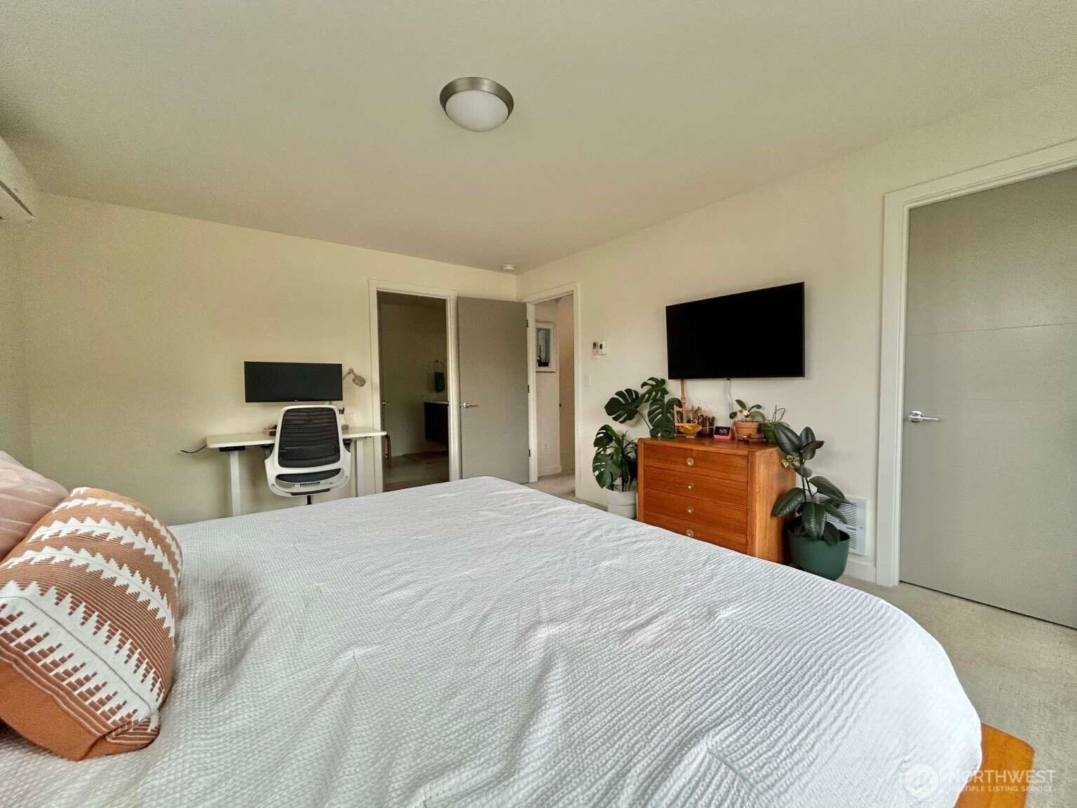 4852 40th Avenue Southwest, Unit B Seattle, WA 98116 - Photo 20 of 25 a bedroom with a bed and a flat tv screen on wall