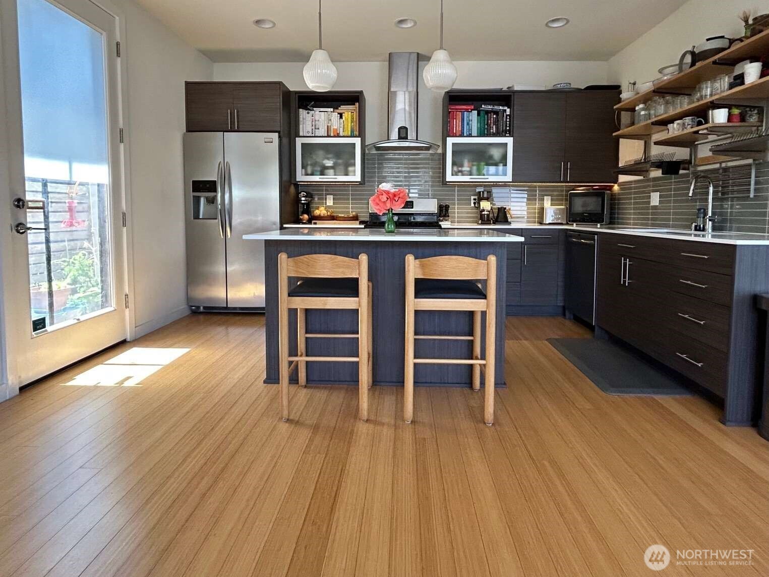 4852 40th Avenue Southwest, Unit B Seattle, WA 98116 - Photo 7 of 25 a kitchen with stainless steel appliances a dining table chairs stove and refrigerator