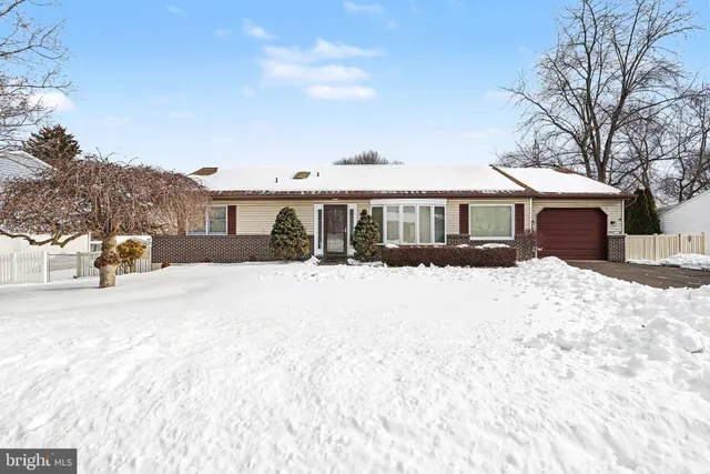 a front view of a house with a yard covered in snow