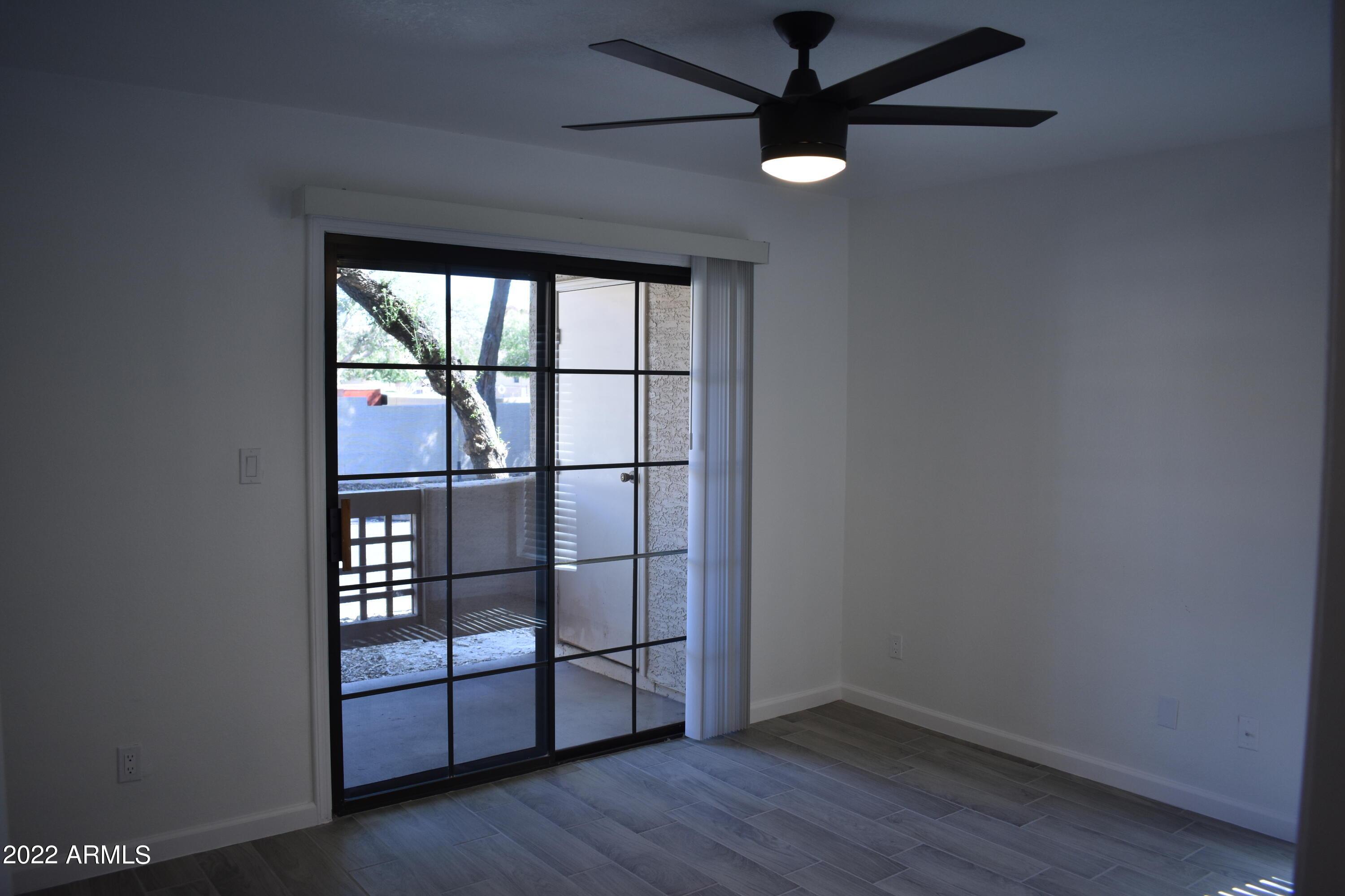2855 South Ext Road, Unit 135 Mesa, AZ 85210 - Photo 11 of 19 an empty room with wooden floor and windows