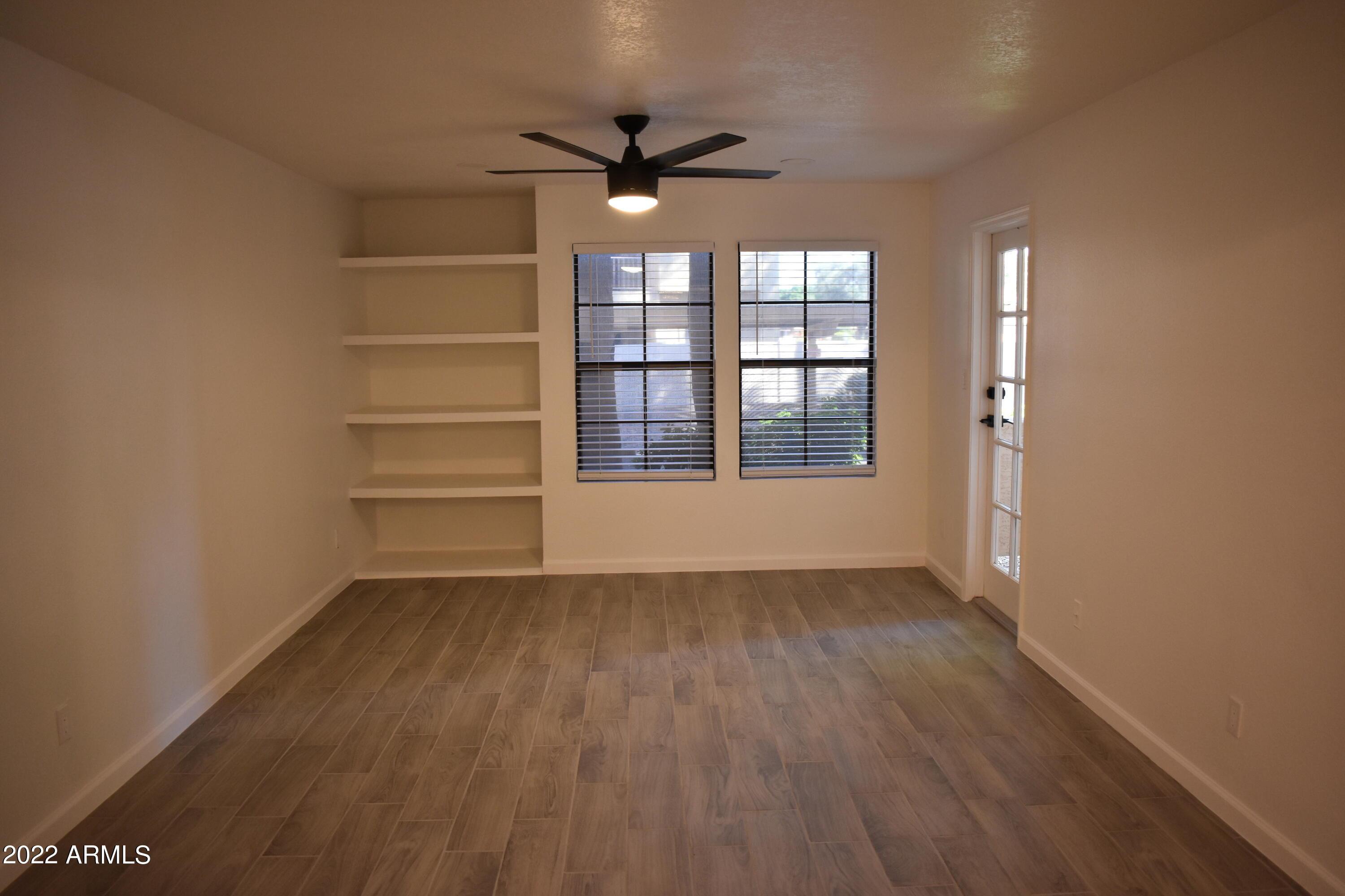 2855 South Ext Road, Unit 135 Mesa, AZ 85210 - Photo 13 of 19 wooden floor in an empty room with a window