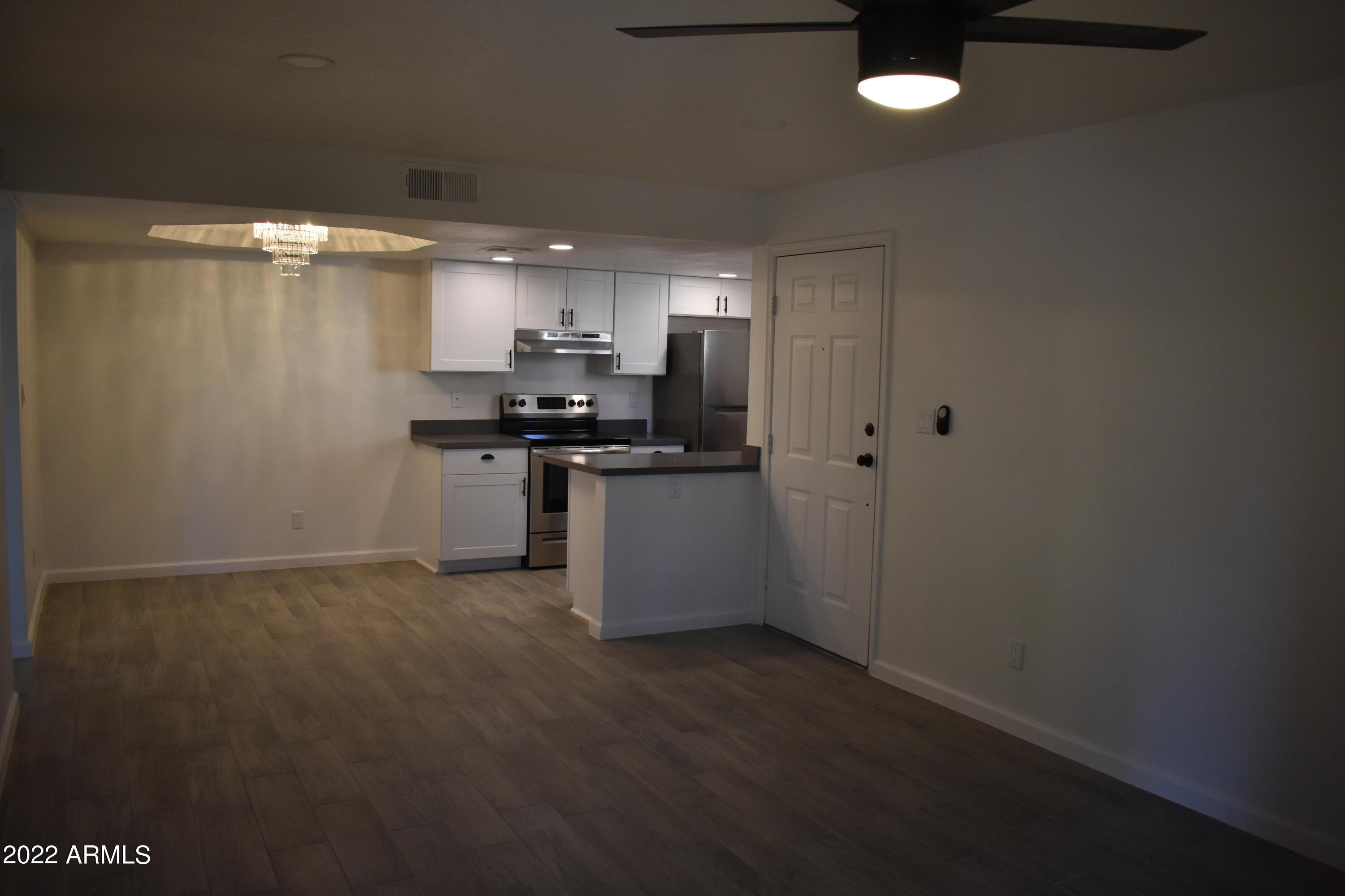 2855 South Ext Road, Unit 135 Mesa, AZ 85210 - Photo 14 of 19 a kitchen with stainless steel appliances a stove a refrigerator a sink a stove with wooden floor