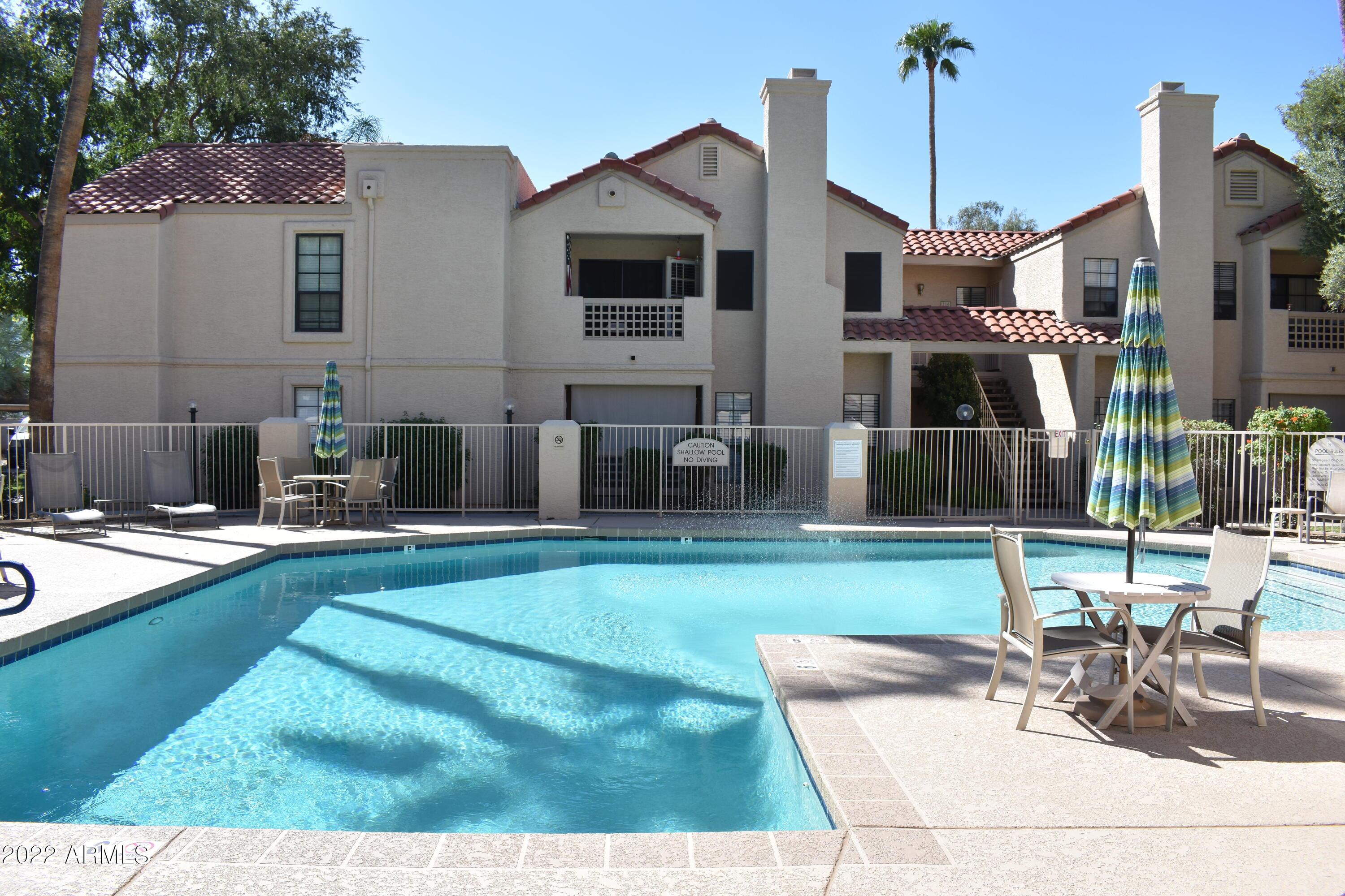 2855 South Ext Road, Unit 135 Mesa, AZ 85210 - Photo 17 of 19 a front view of a house with swimming pool having outdoor seating