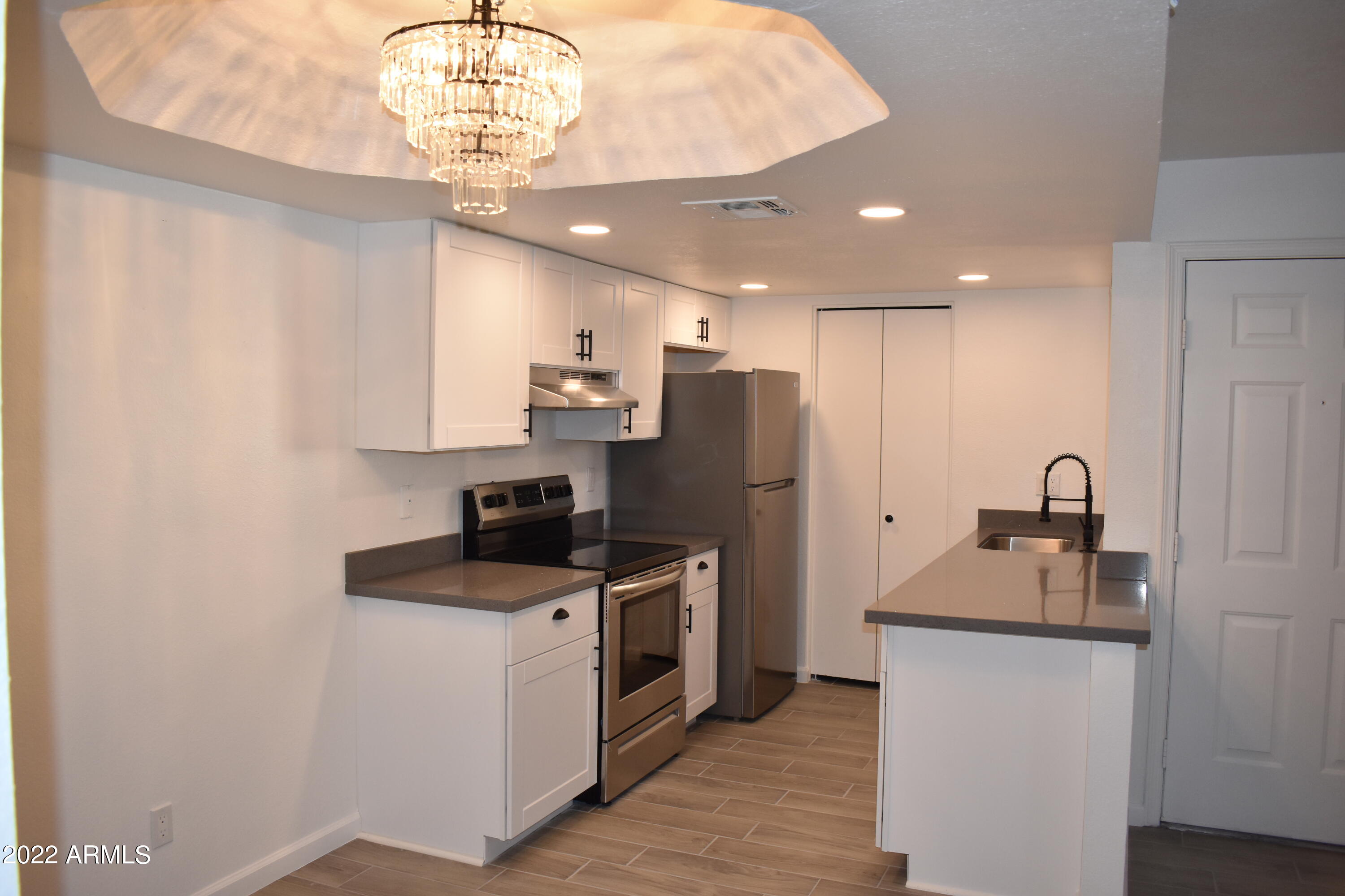 2855 South Ext Road, Unit 135 Mesa, AZ 85210 - Photo 2 of 19 a kitchen with stainless steel appliances granite countertop a sink stove and refrigerator