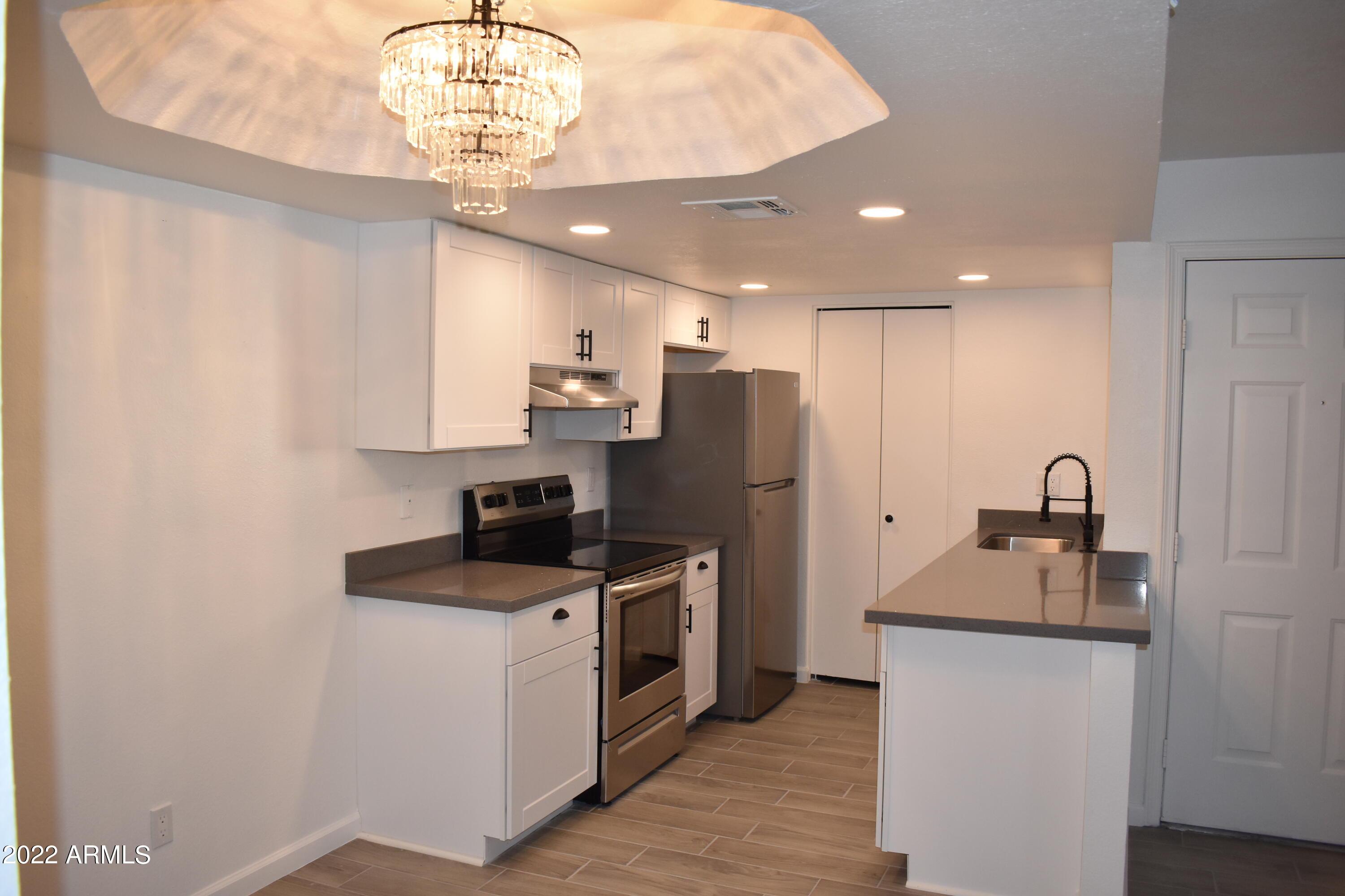 2855 South Ext Road, Unit 135 Mesa, AZ 85210 - Photo 2 of 19 a kitchen with stainless steel appliances granite countertop a sink stove and refrigerator