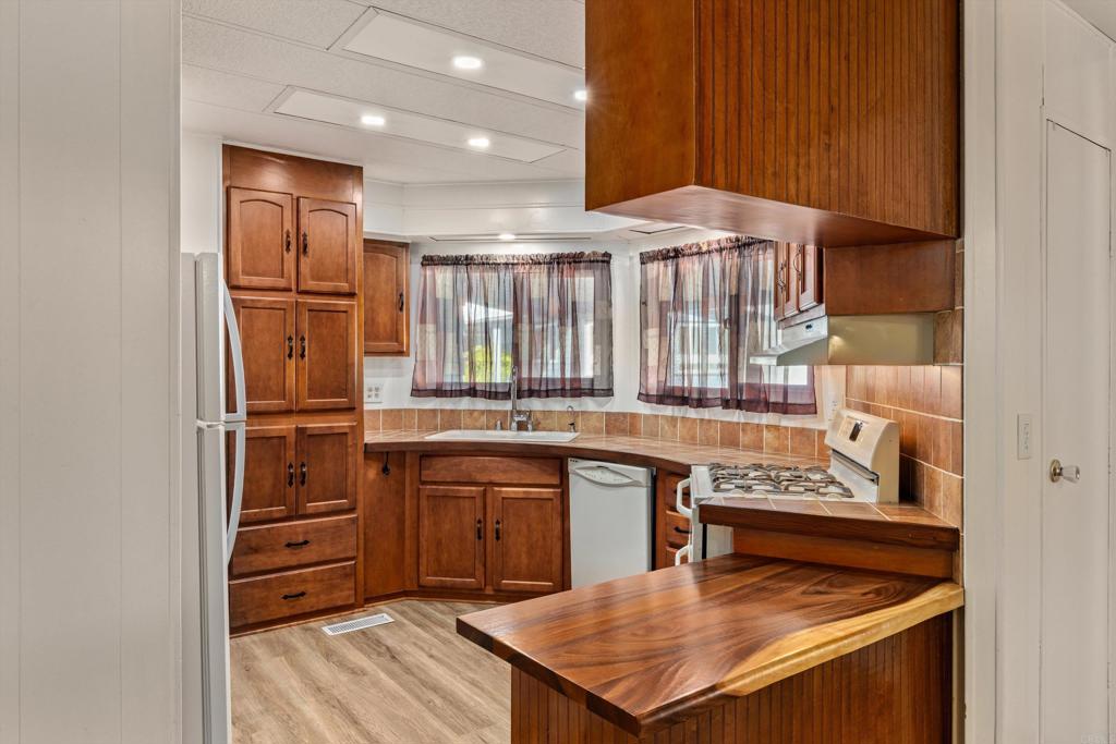 650 South Rancho Santa Fe Road, Unit 312 San Marcos, CA 92078 - Photo 12 of 53 a kitchen with stainless steel appliances granite countertop a stove a sink and a refrigerator