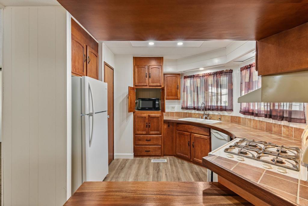 650 South Rancho Santa Fe Road, Unit 312 San Marcos, CA 92078 - Photo 14 of 53 a kitchen with stainless steel appliances granite countertop a refrigerator and a stove top oven