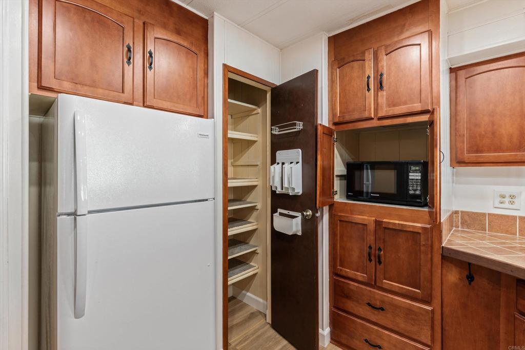 650 South Rancho Santa Fe Road, Unit 312 San Marcos, CA 92078 - Photo 15 of 53 a white refrigerator freezer and a stove sitting inside of a kitchen