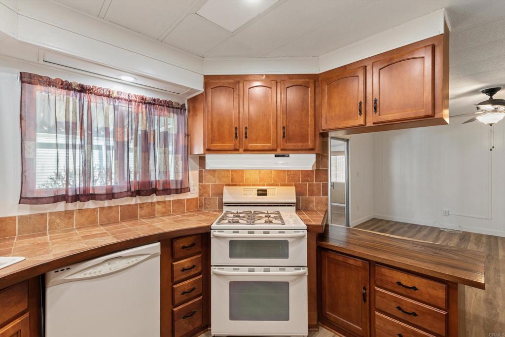 650 South Rancho Santa Fe Road, Unit 312 San Marcos, CA 92078 - Photo 16 of 53 a kitchen with wooden cabinets stove top oven and sink