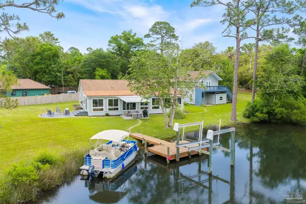 an aerial view of a house with a swimming pool patio and lake view
