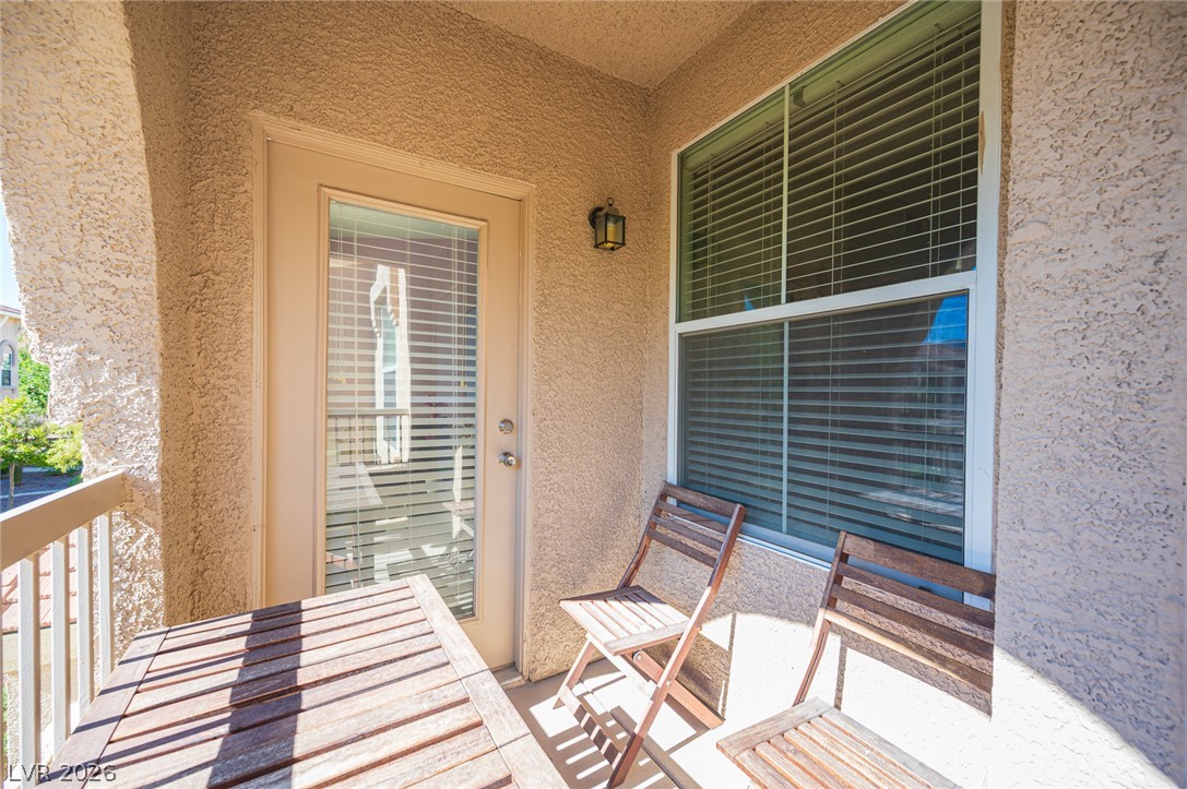 10550 West Alexander Road, Unit 2014 Las Vegas, NV 89129 - Photo 35 of 43 Private covered balcony features stucco walls and a glass-paneled exterior door.