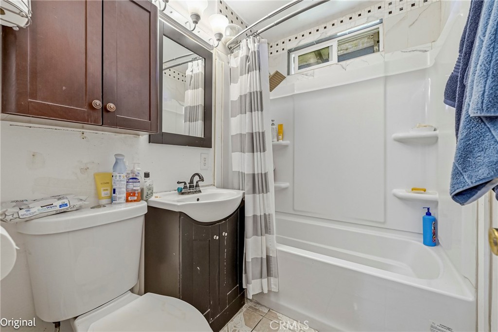 1054 West 24th Street Merced, CA 95340 - Photo 19 of 39 a bathroom with a sink a toilet and shower