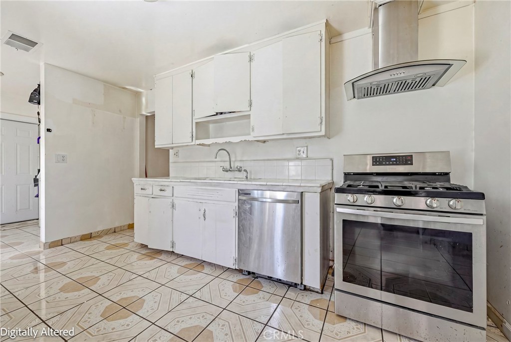 1054 West 24th Street Merced, CA 95340 - Photo 23 of 39 a kitchen with white cabinets and appliances