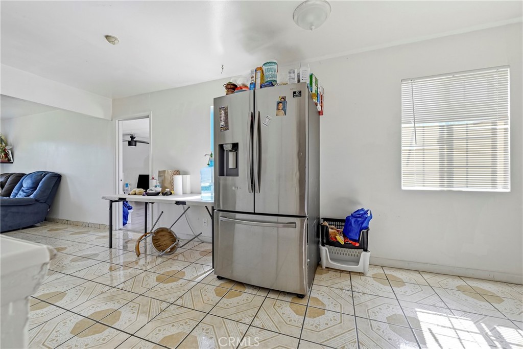 1054 West 24th Street Merced, CA 95340 - Photo 28 of 39 a kitchen with refrigerator and table