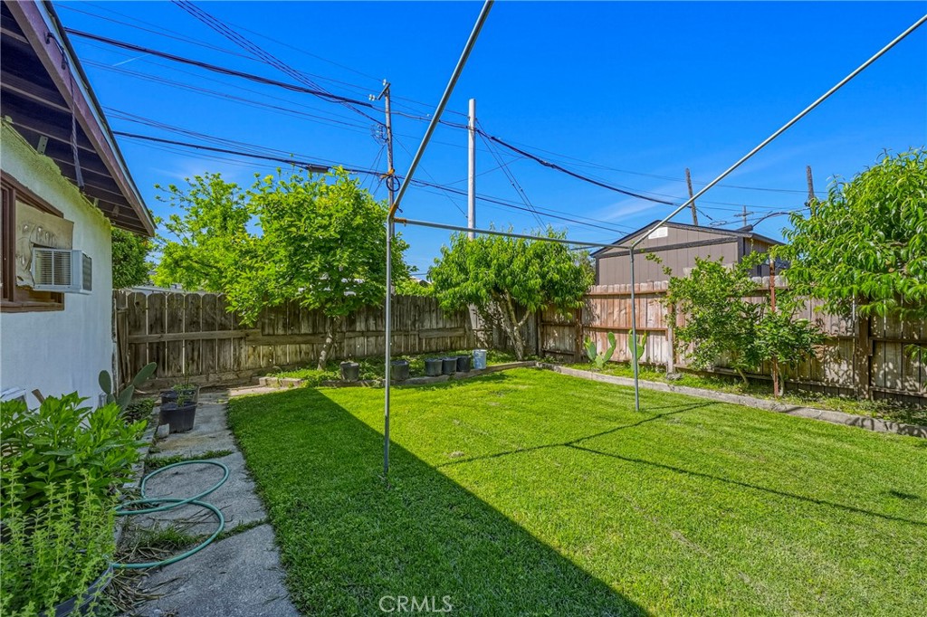 1054 West 24th Street Merced, CA 95340 - Photo 34 of 39 a view of a backyard with table and chairs under an umbrella