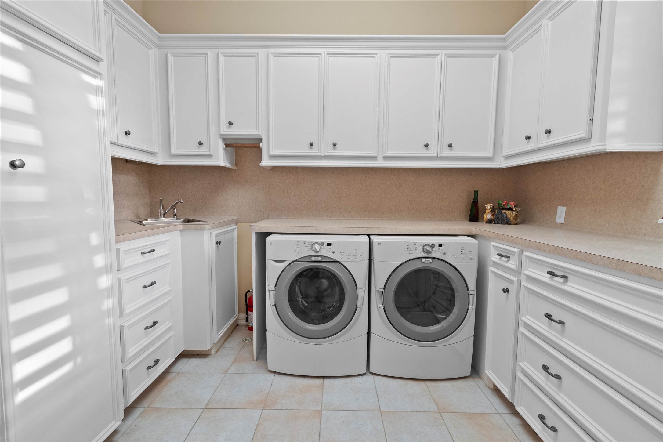 16626 Lafone Drive Spring, TX 77379 - Photo 39 of 42 Utility room with a sink, tons of storage and an ironing board.