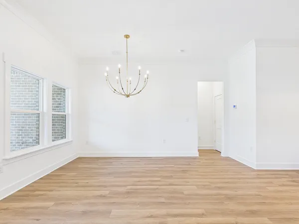 an empty room with wooden floor and fan
