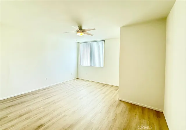 an empty room with a window and a ceiling fan