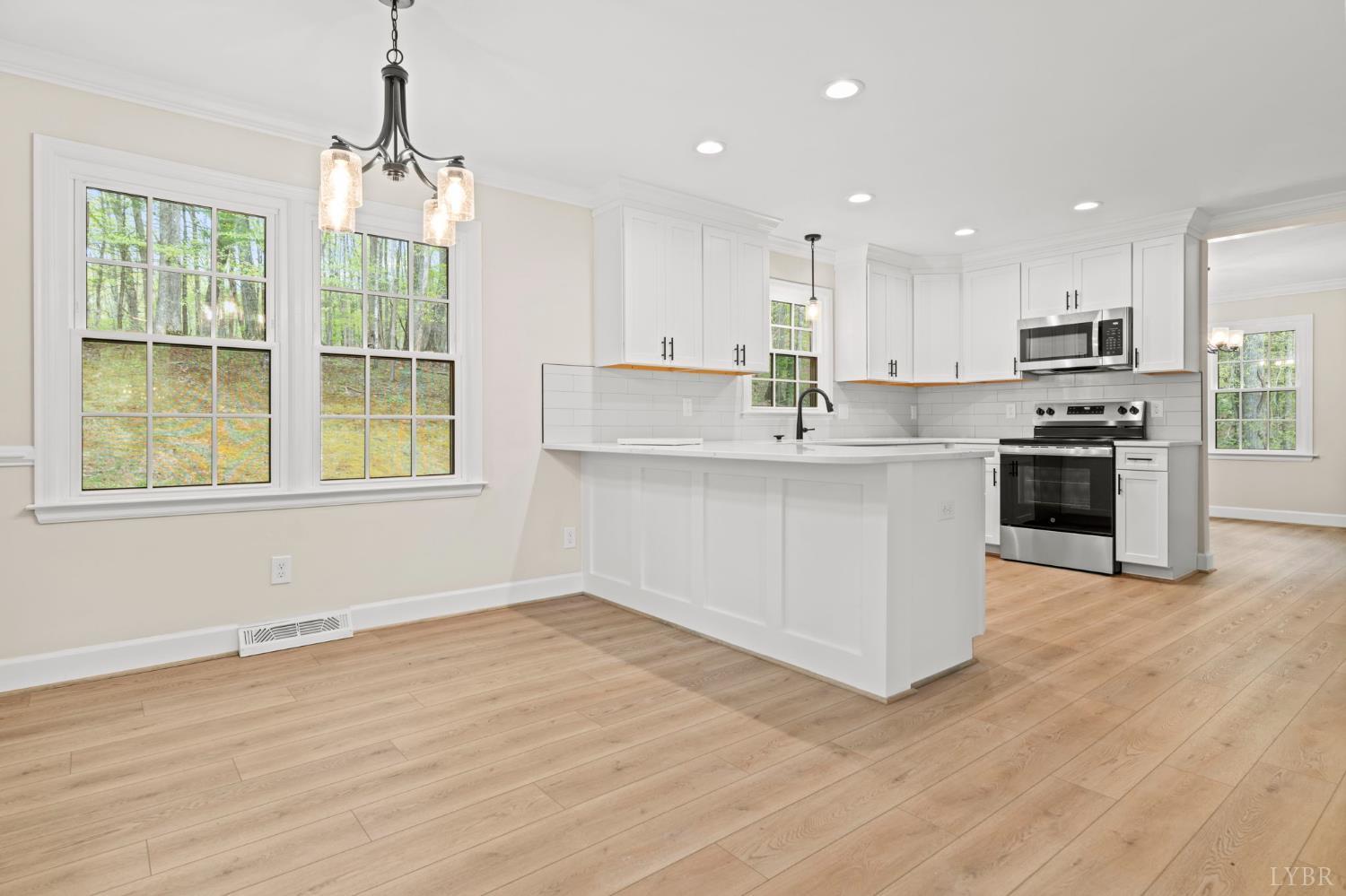 2252 Coffee Road Lynchburg, VA 24503 - Photo 36 of 93 a kitchen with stainless steel appliances granite countertop a stove top oven a sink dishwasher a refrigerator and a dining table with wooden floor