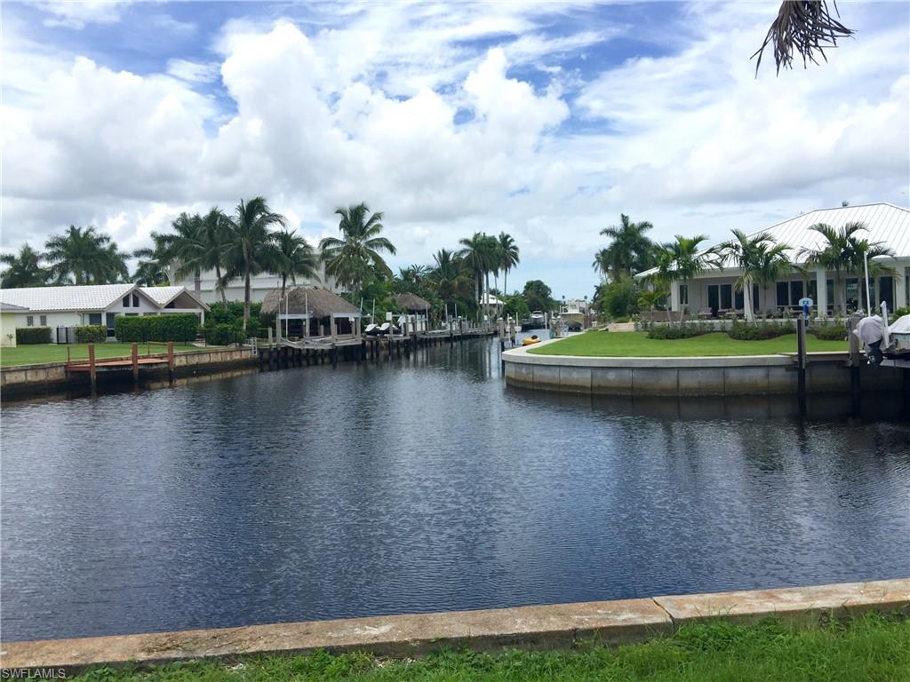 1809 Kingfish Road Naples, FL 34102 - Photo 4 of 8 a view of a lake with houses in the back