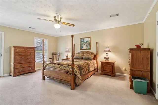 a bedroom with a bed and dresser with mirror
