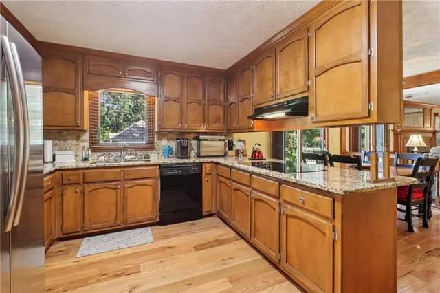 a kitchen with stainless steel appliances granite countertop a stove a sink and a refrigerator