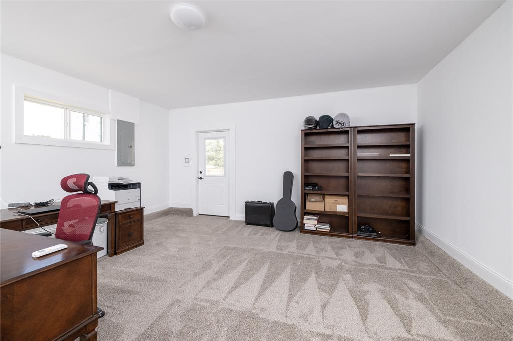 151 County Road 3699 Springtown, TX 76082 - Photo 26 of 35 Spacious room featuring light gray patterned carpet, white walls, and bright overhead lighting