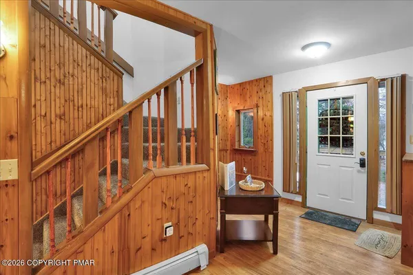 a view of an entryway with wooden floor and door